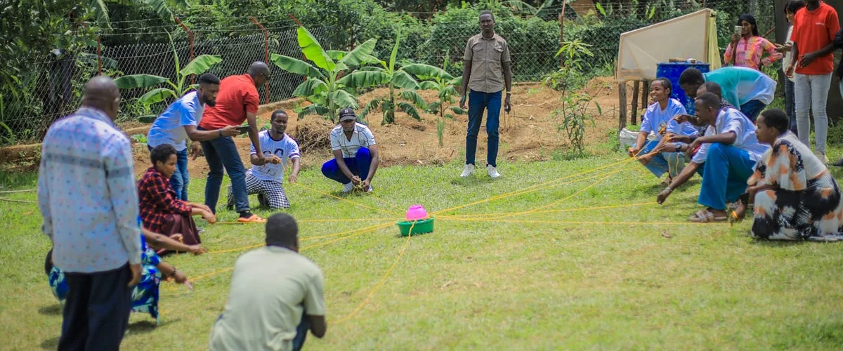 Participants playing a team game outdoors on the grass during the training