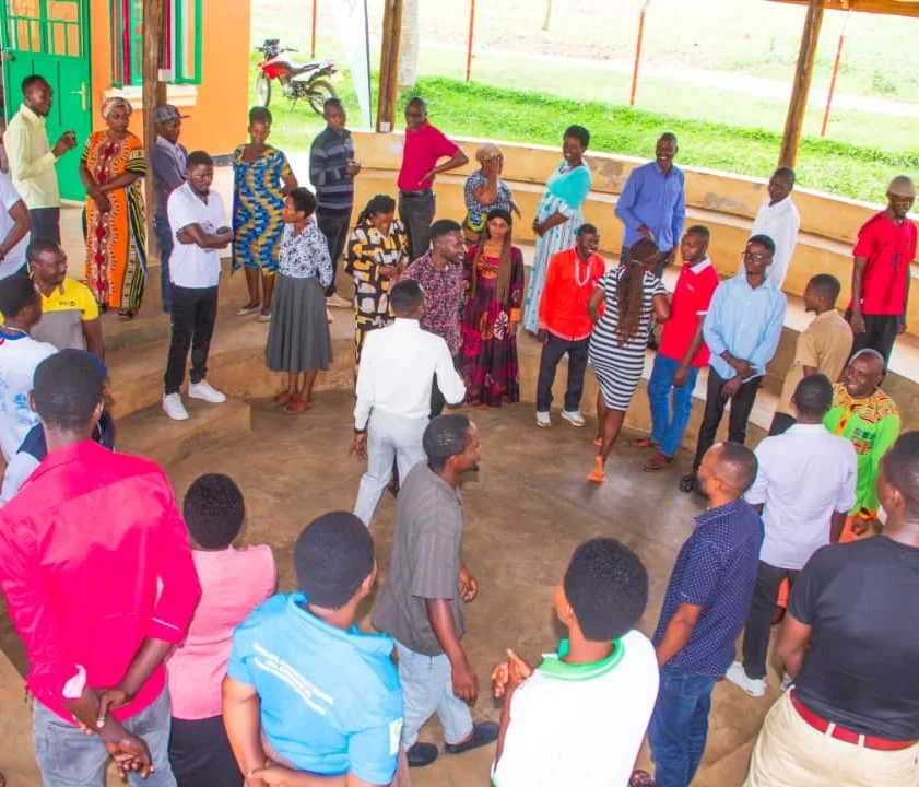 Participants standing in a circle during a Personal Initiative Training session in Kyaka II