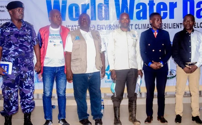 Panellists, including a police officer, standing in front of the World Water Day banner