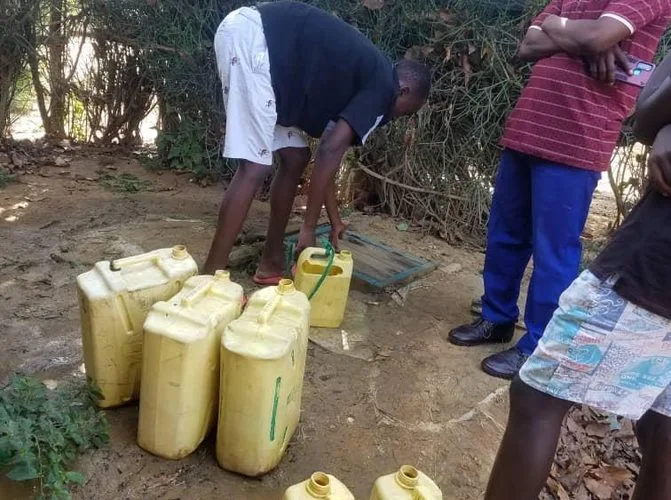 Yellow jerrycans lined up at a local water source in Nakivale