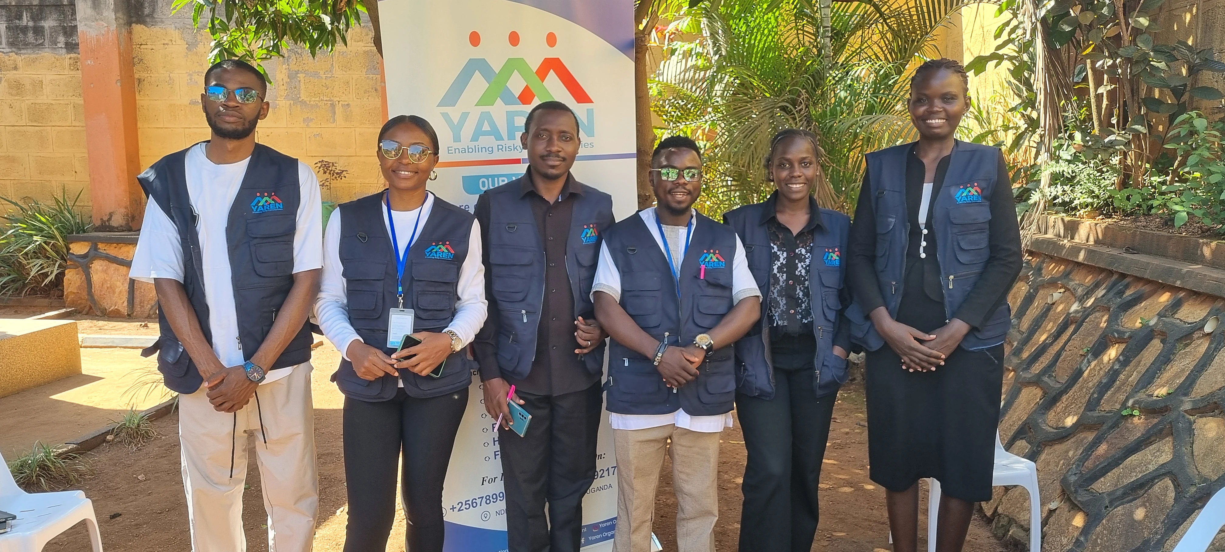 YAREN team members standing together in front of a YAREN banner